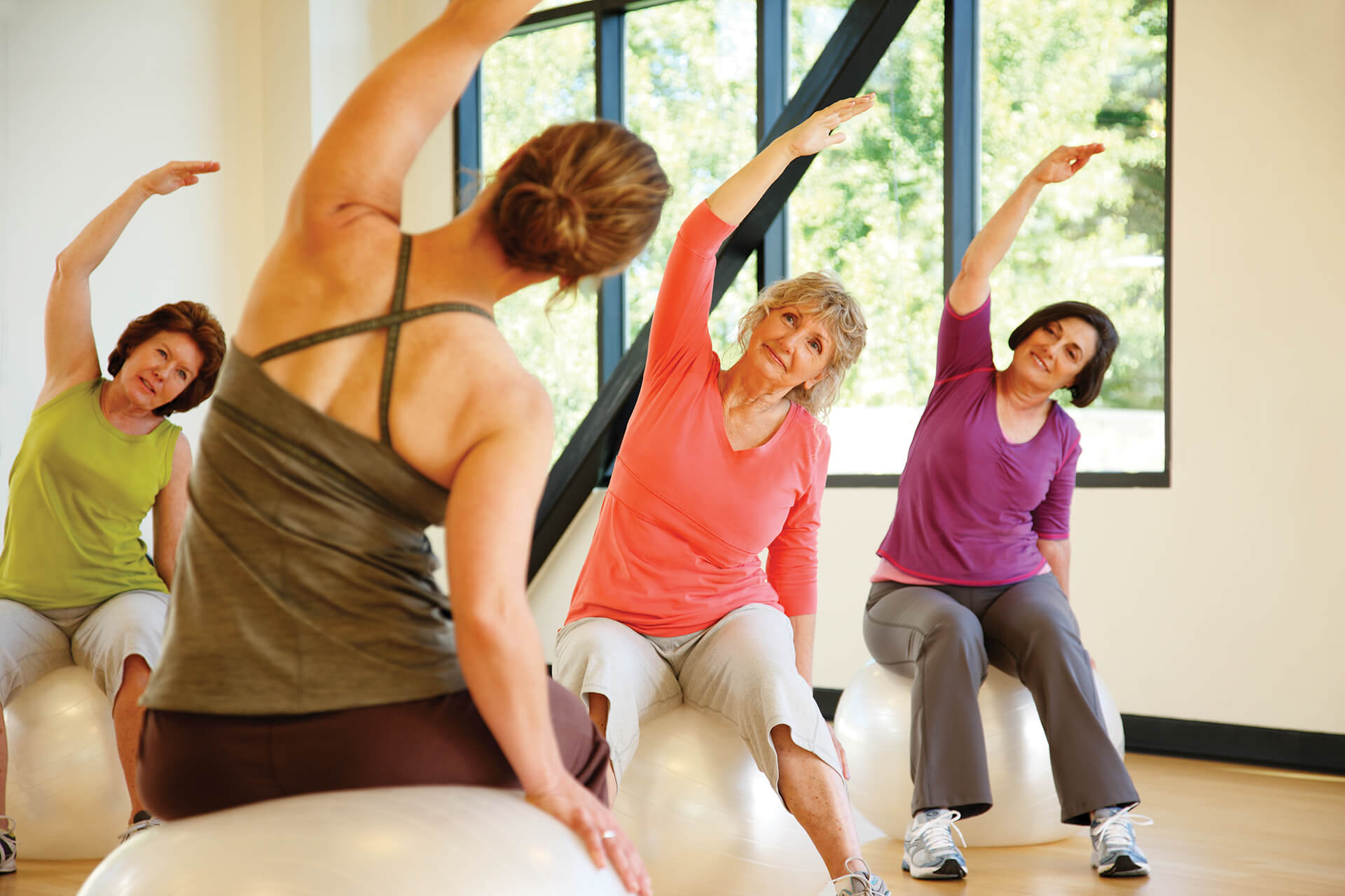 Photo of women in exercise class sitting on therapy balls