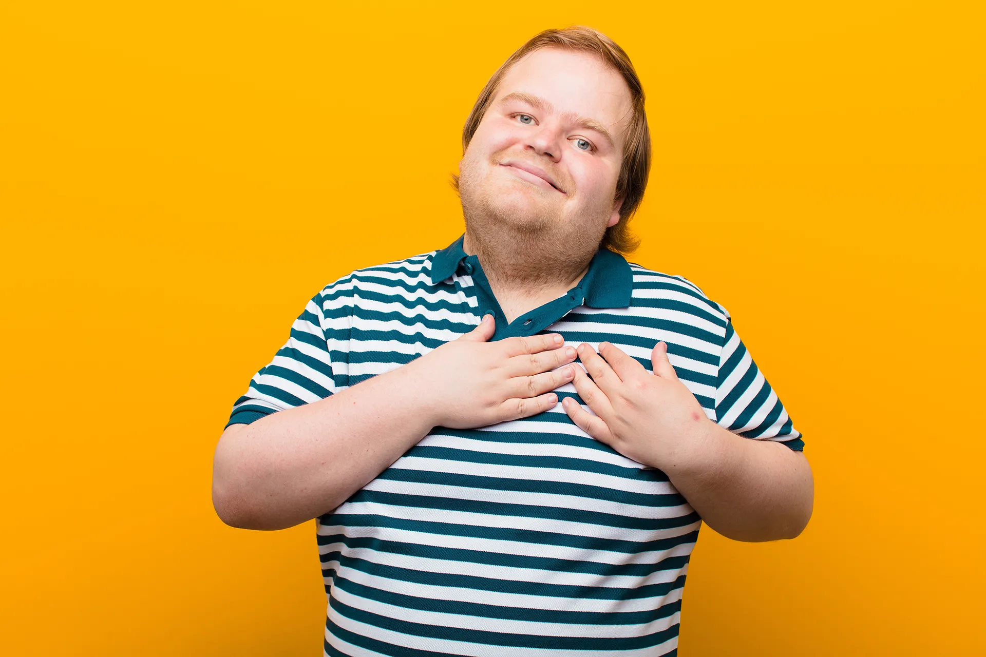 Man smiling with hands on his heart width=