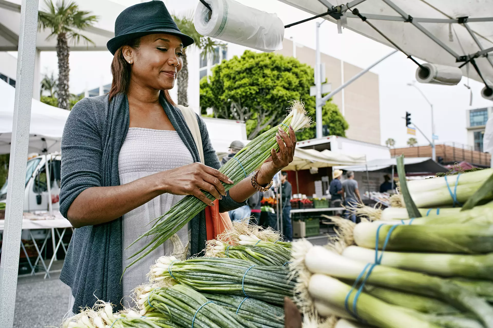 Woman at farmers market picking out green onions