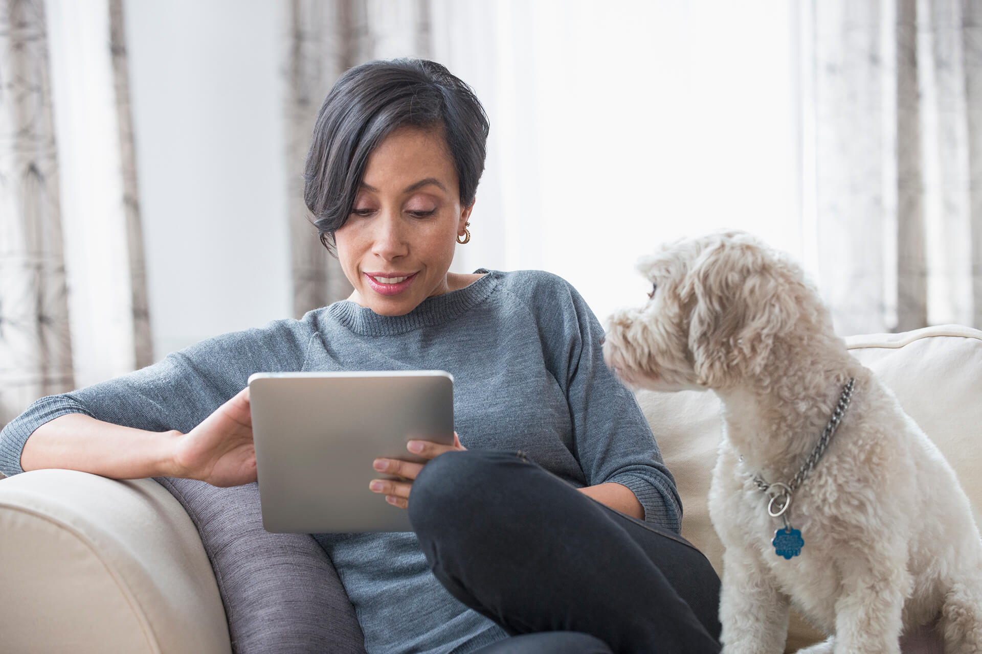 Photo of woman sitting on couch on an ipad