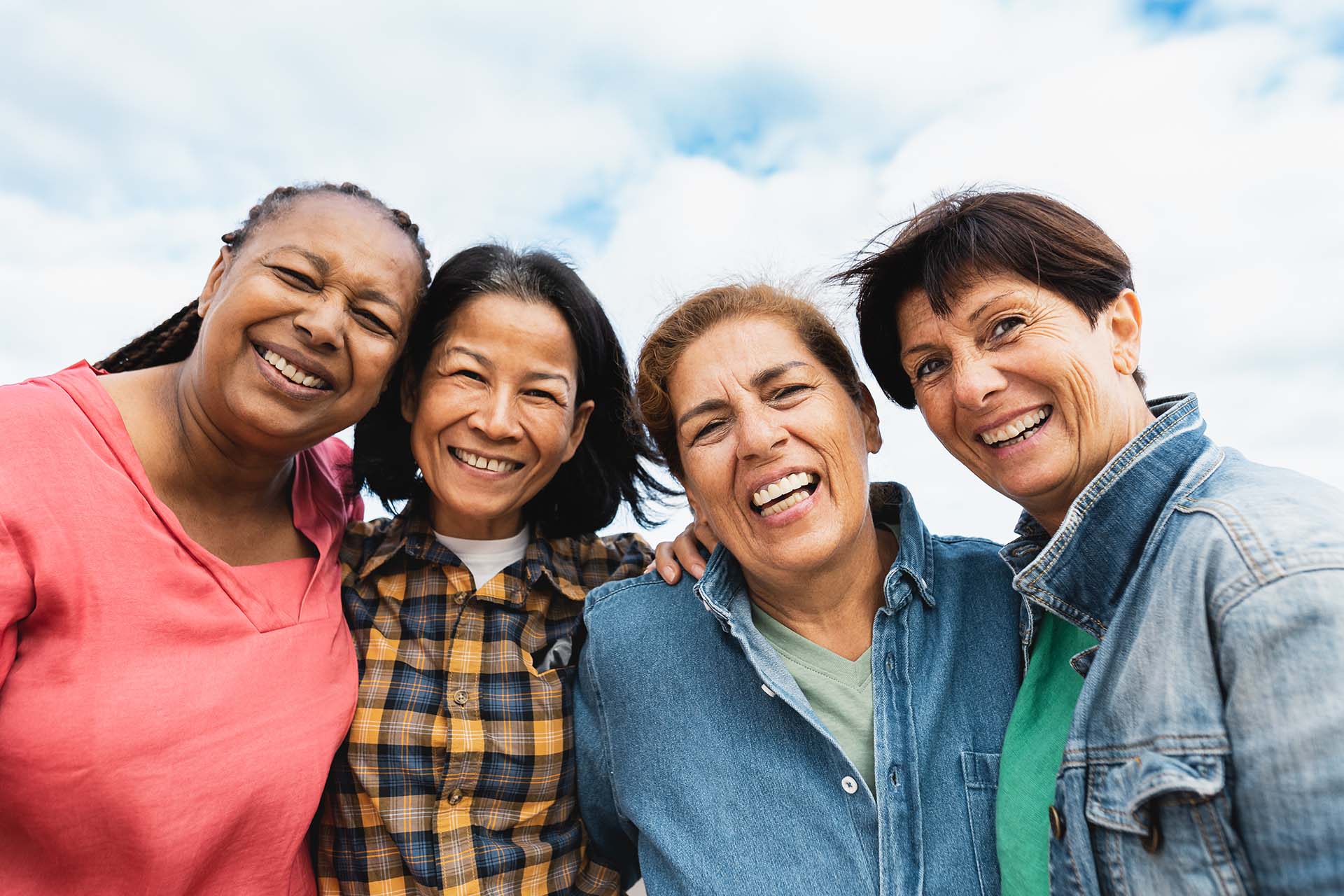 Four middle aged women smiling